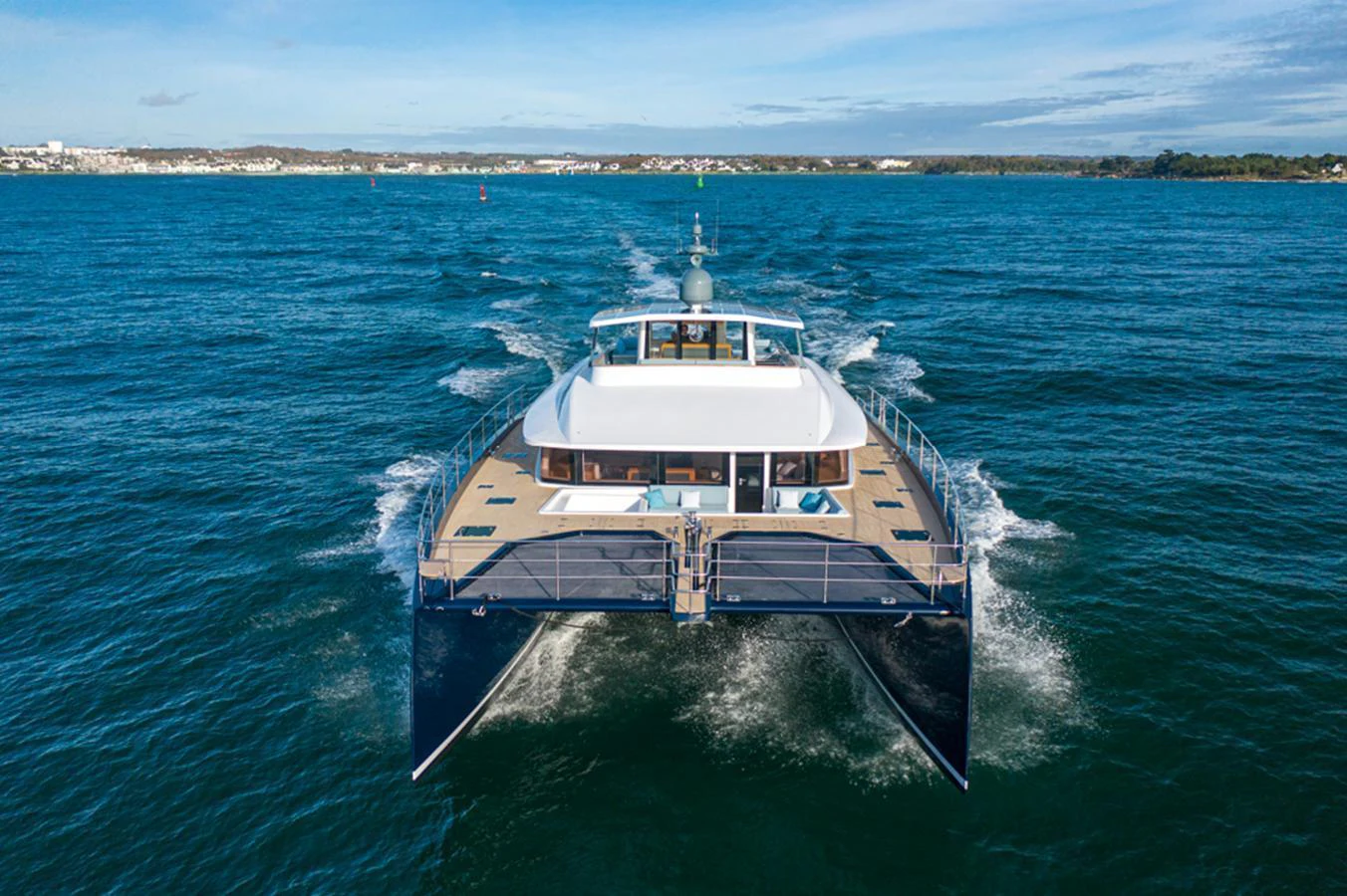 A sleek catamaran yacht glides through the water, showcasing its modern design and spacious deck. aboard LONG ISLAND 78 Yacht for Sale