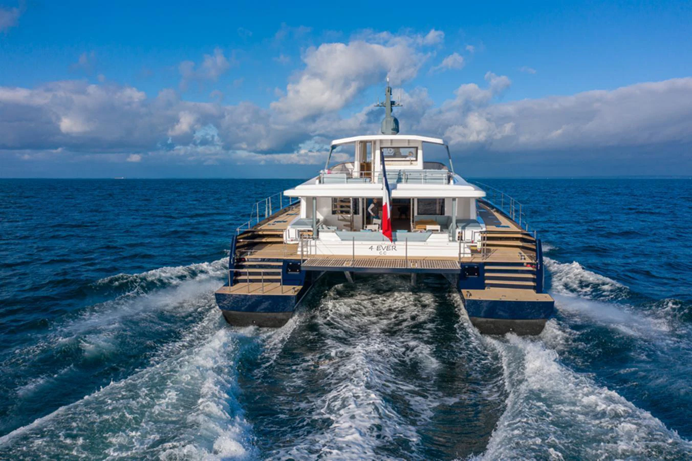 A luxurious catamaran yacht cruising on open waters with a spacious aft deck. aboard LONG ISLAND 78 Yacht for Sale