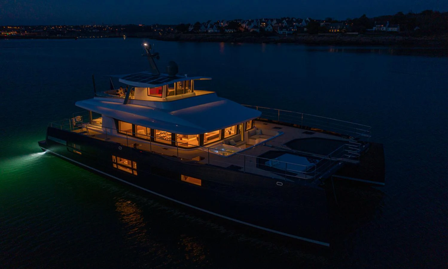 A luxurious yacht is beautifully illuminated at night, showcasing its sleek design and inviting ambiance. aboard LONG ISLAND 78 Yacht for Sale
