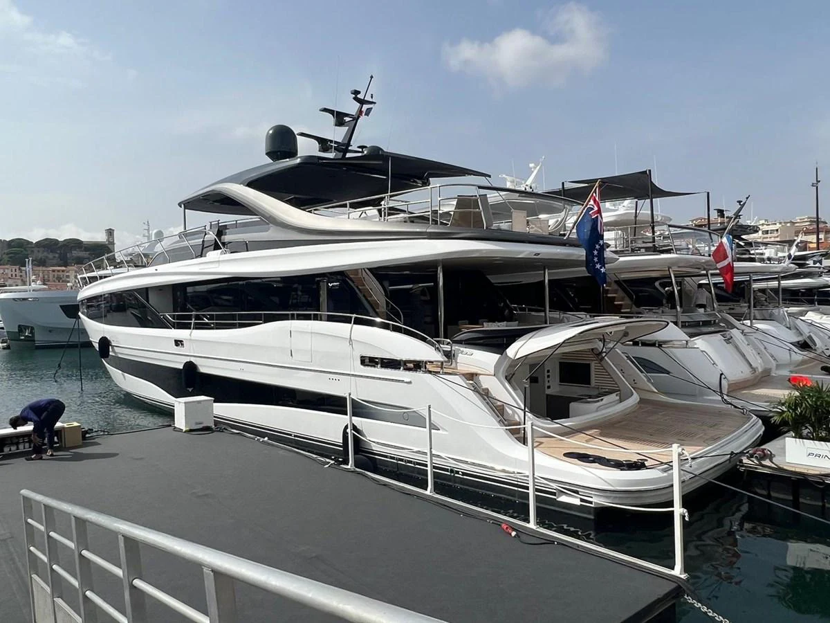A sleek and modern yacht docked at a marina, showcasing its elegant design and spacious deck. aboard LEILANI Yacht for Sale