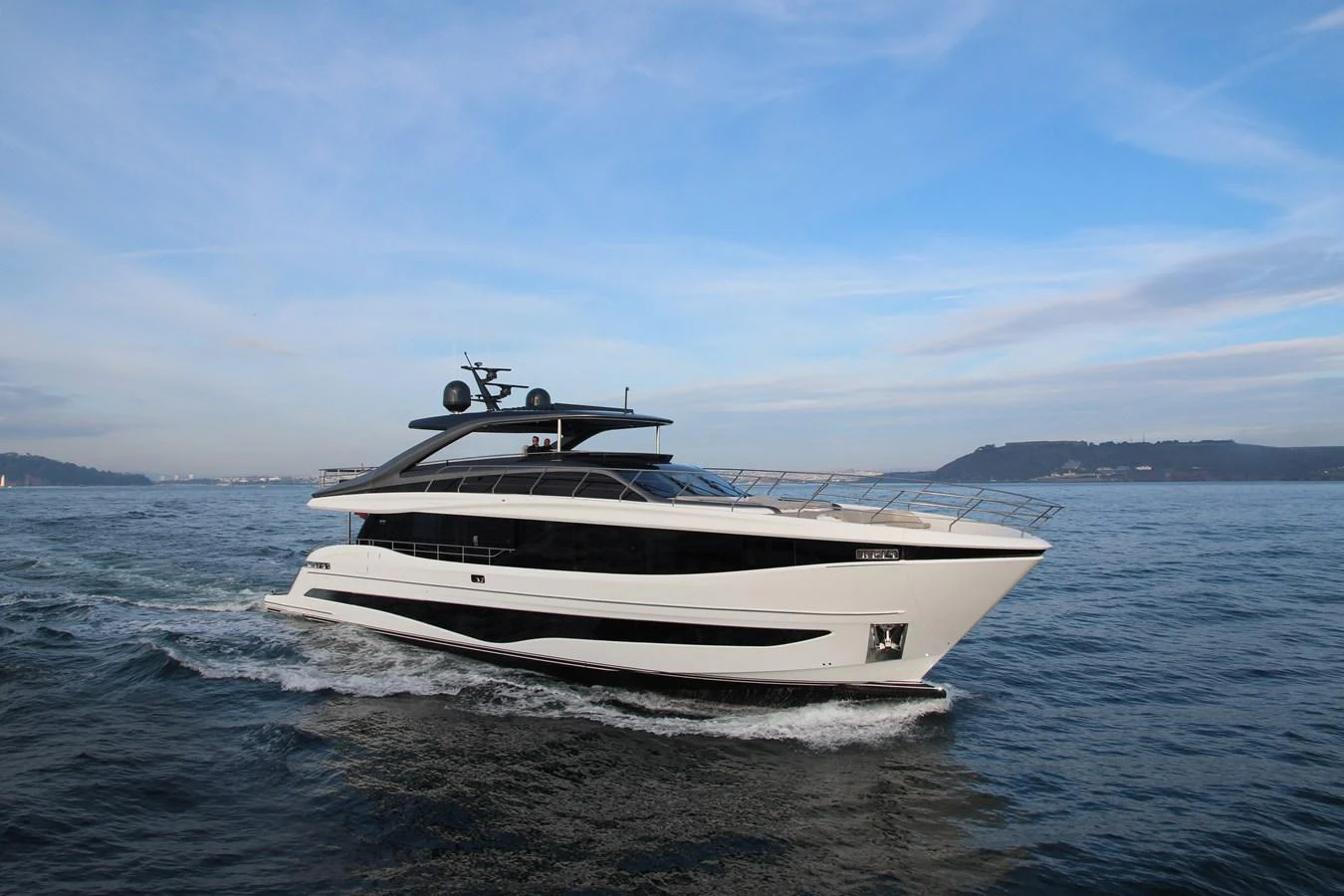 A sleek and modern yacht glides through the water under a clear blue sky. aboard LEILANI Yacht for Sale