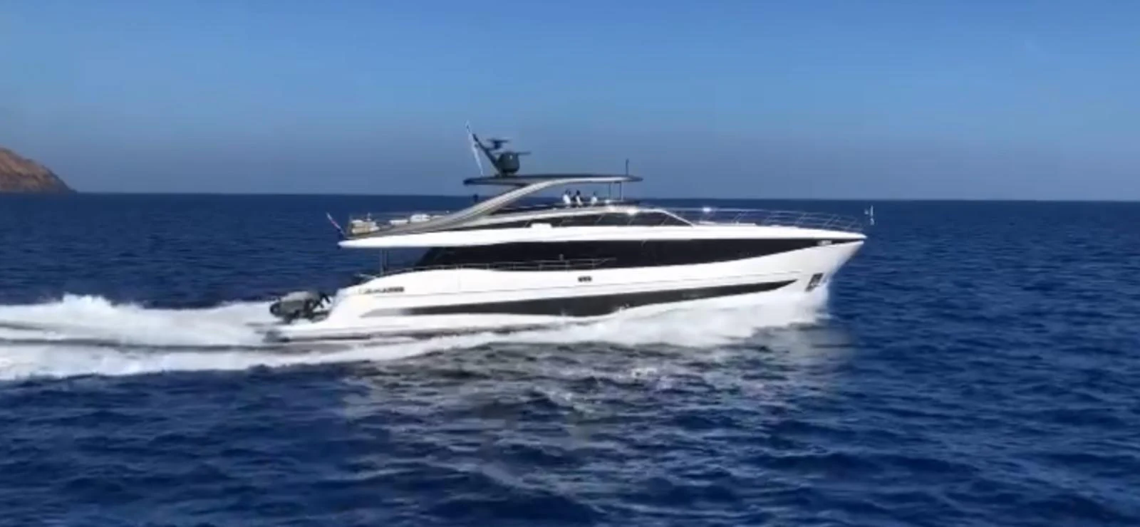 A sleek yacht cruises through the open sea under a clear blue sky. aboard LEILANI Yacht for Sale