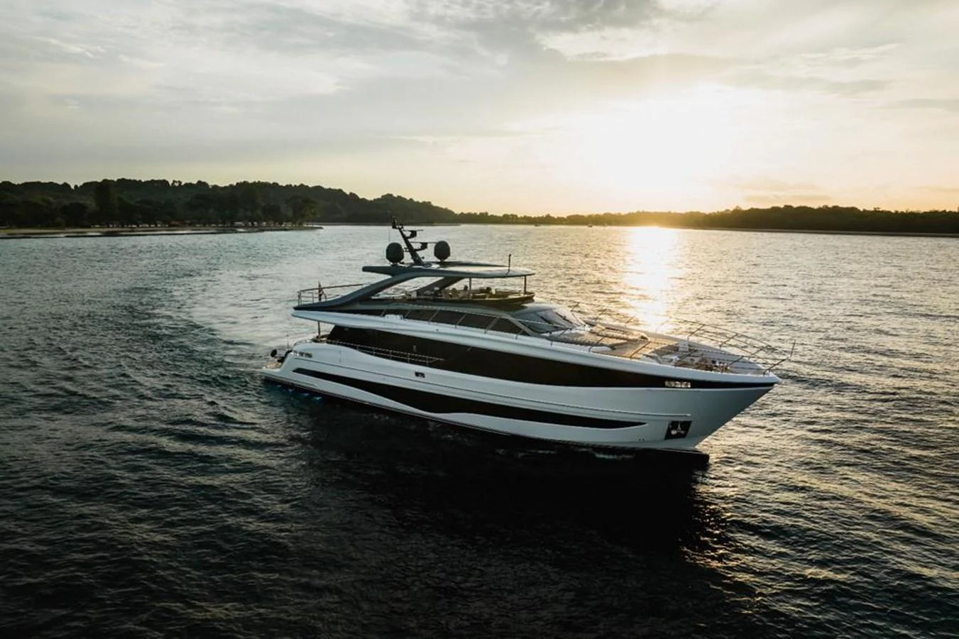 A sleek yacht cruises gracefully on the water at sunset. aboard LEILANI Yacht for Sale