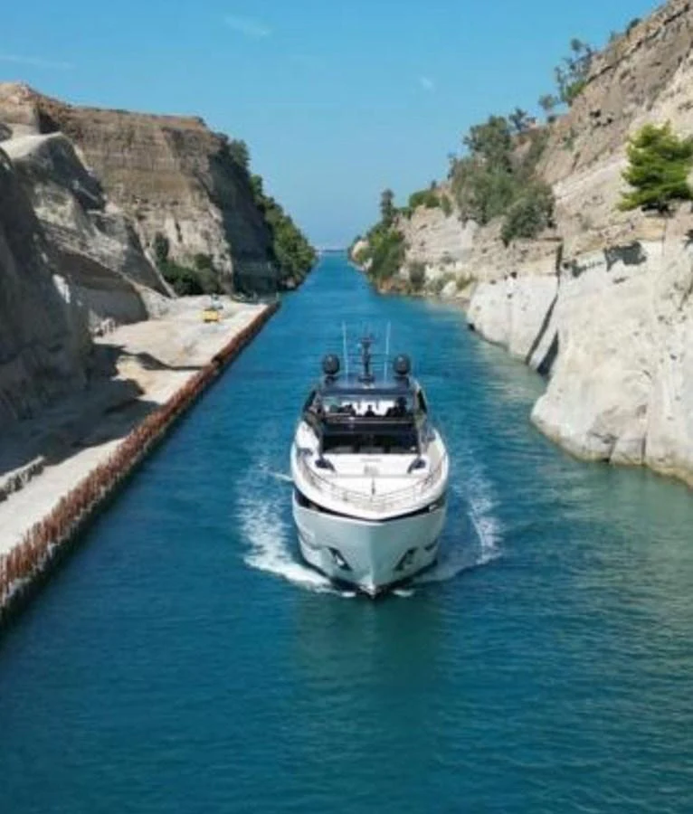 A sleek yacht navigates through a narrow canal, showcasing its impressive design and maneuverability. aboard LEILANI Yacht for Sale