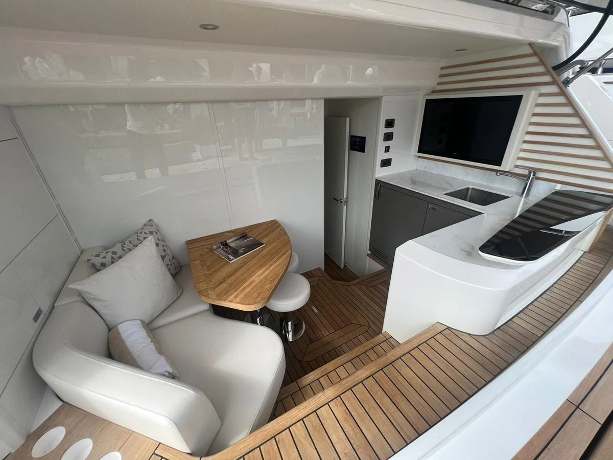 The yacht's galley features a sleek design with a cozy seating area and modern amenities. aboard LEILANI Yacht for Sale