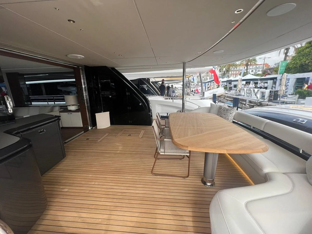 The aft deck features a spacious dining area with a wooden table and comfortable seating. aboard LEILANI Yacht for Sale