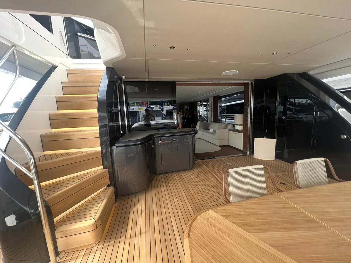 The aft deck features elegant wooden flooring, a staircase, and comfortable seating for a luxurious experience. aboard LEILANI Yacht for Sale