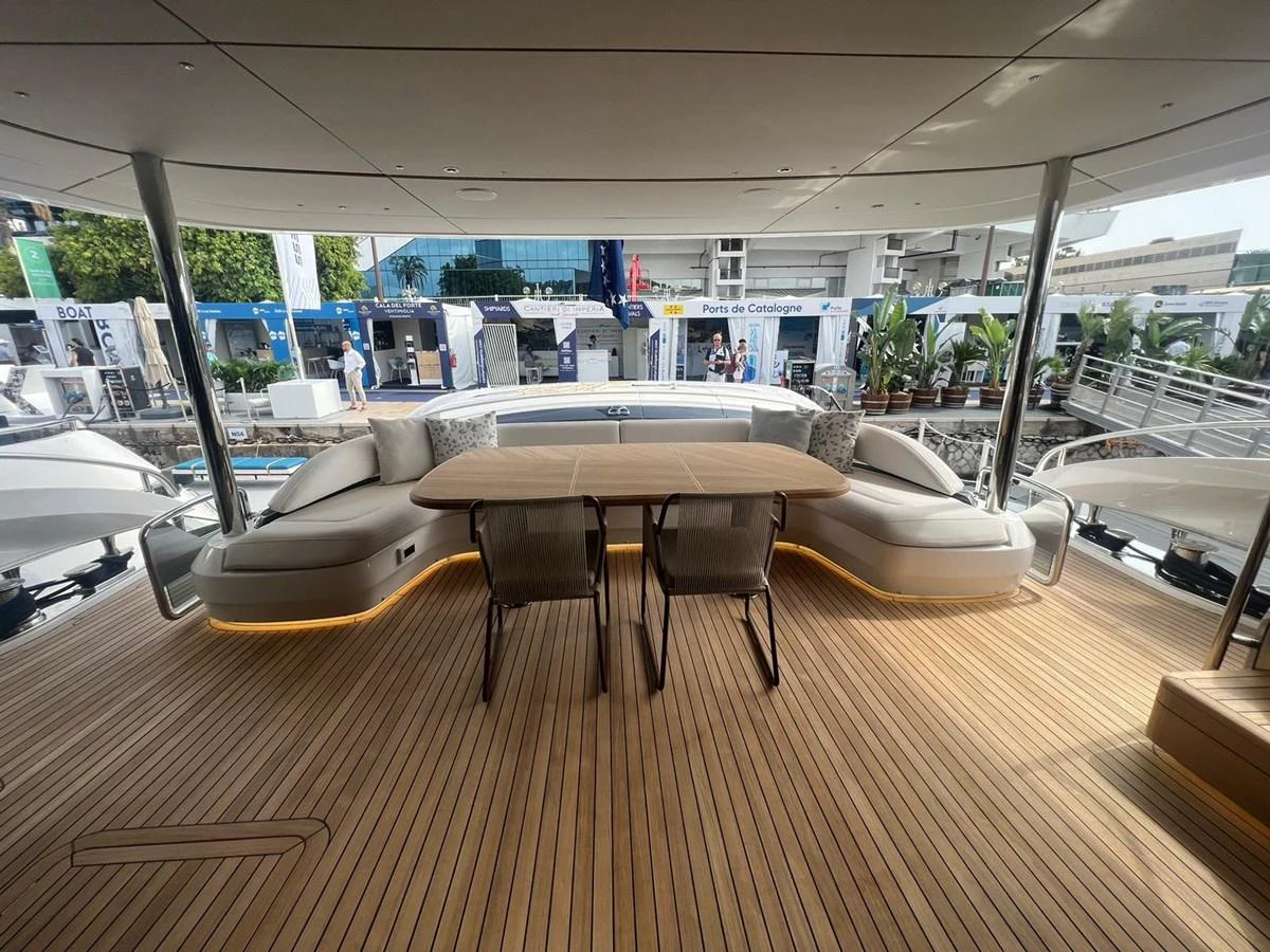 The aft deck features a spacious seating area with a wooden table, perfect for outdoor dining and relaxation. aboard LEILANI Yacht for Sale