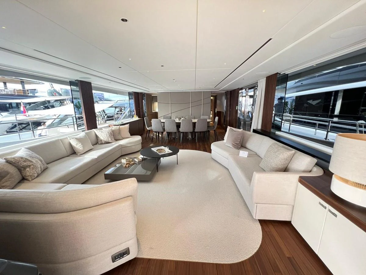 The salon features elegant seating and a dining area with large windows providing ample natural light. aboard LEILANI Yacht for Sale