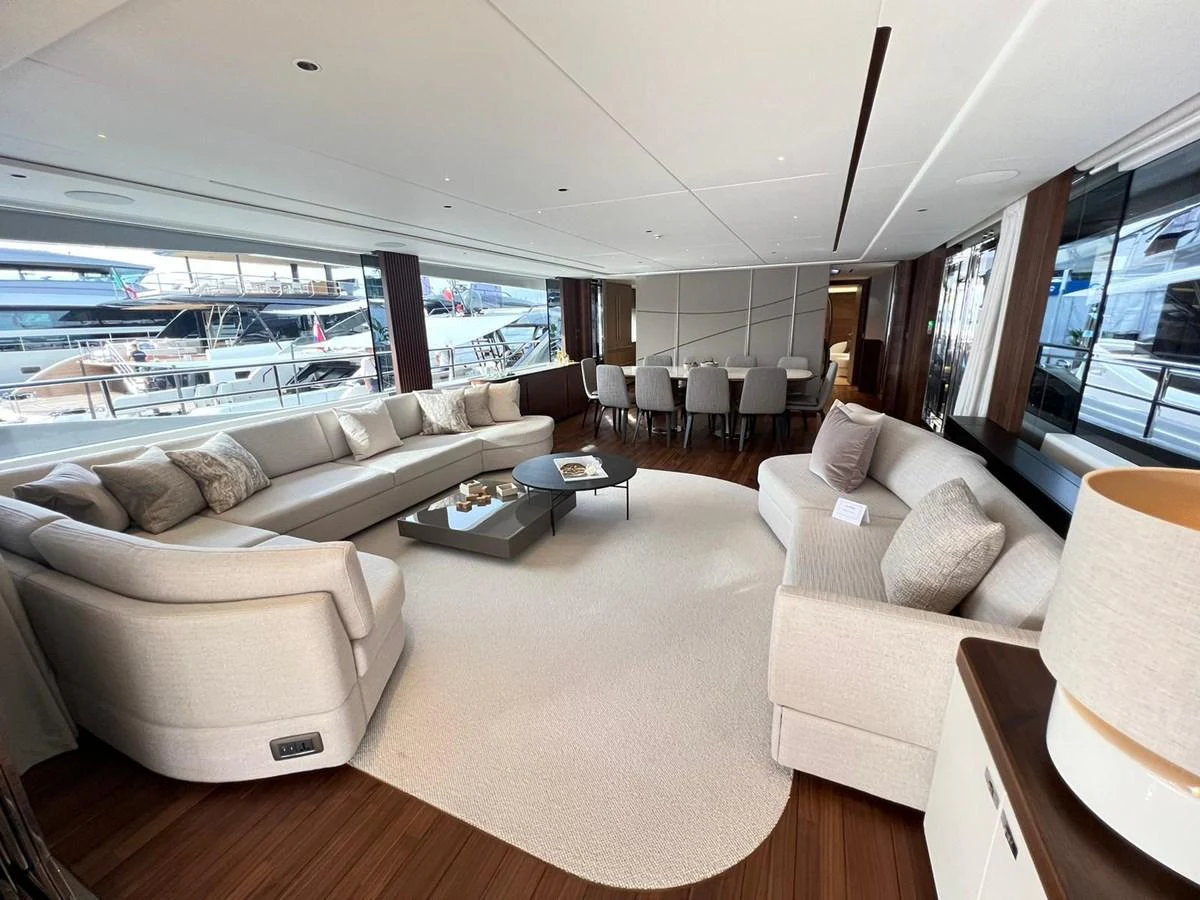 The spacious salon features elegant seating and a dining area with large windows offering stunning views. aboard LEILANI Yacht for Sale
