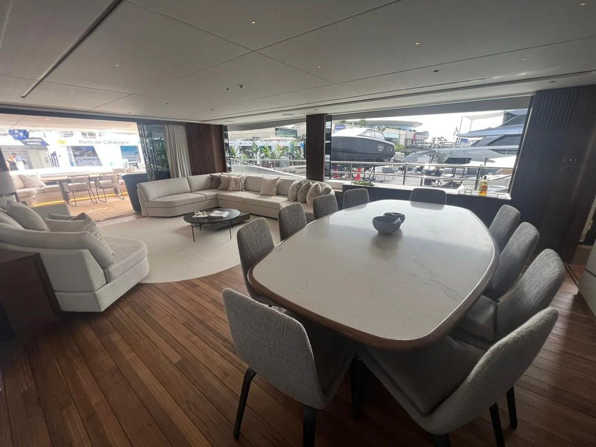 The spacious salon features a comfortable seating area and a dining table with a view of the marina. aboard LEILANI Yacht for Sale