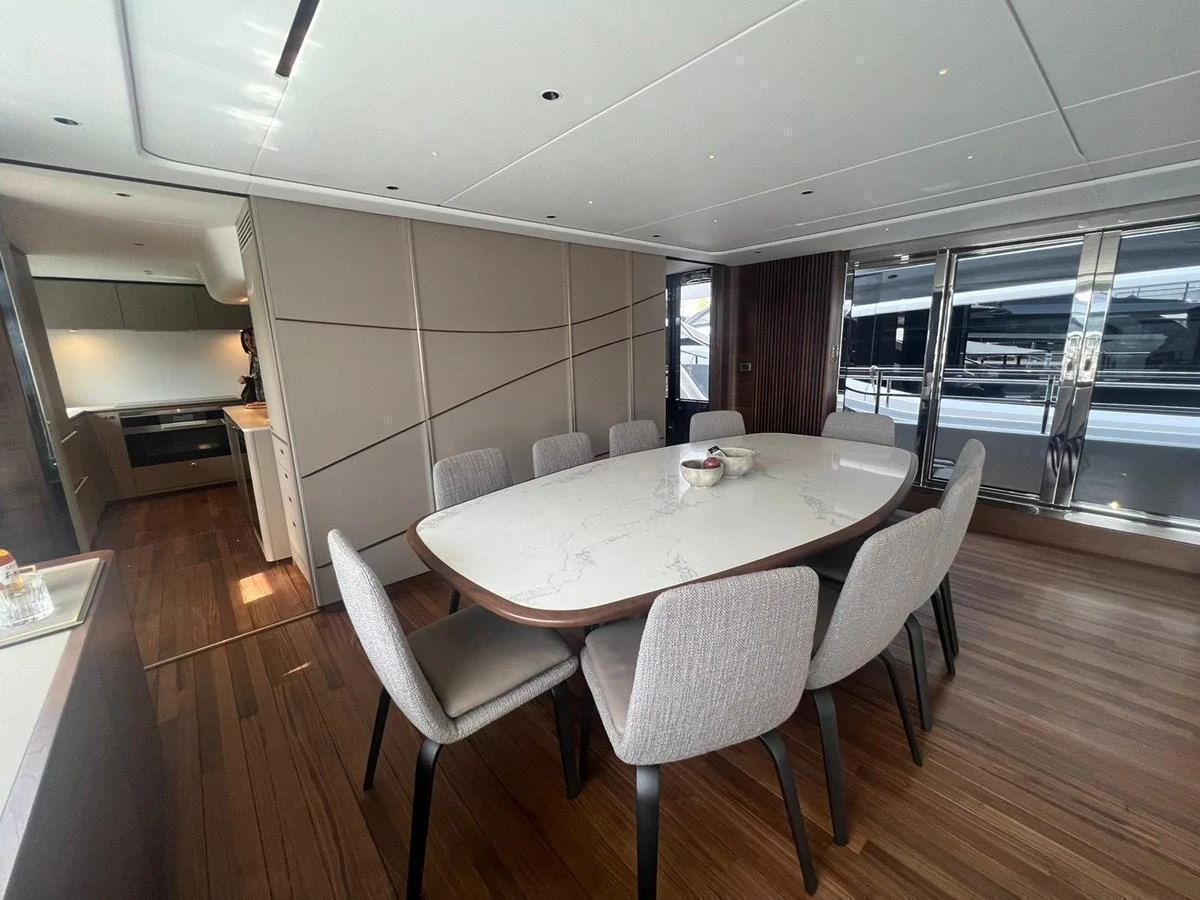 The yacht's dining area features a modern table with comfortable seating and a sleek design. aboard LEILANI Yacht for Sale