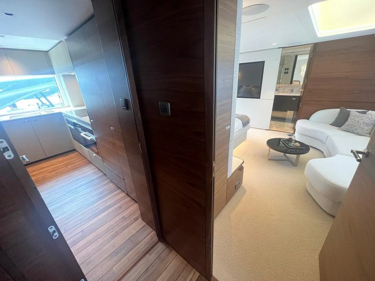 The yacht's salon features a cozy seating area with modern furnishings and a view into the galley. aboard LEILANI Yacht for Sale