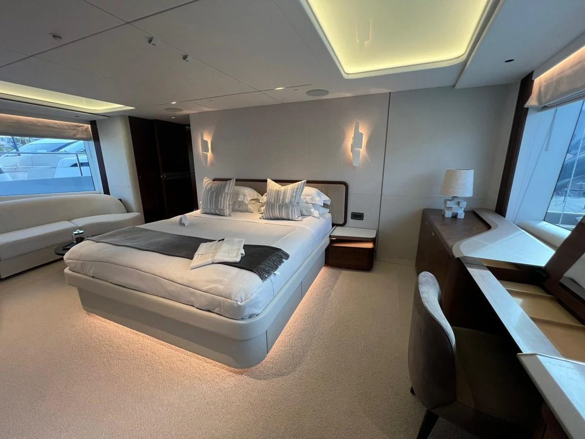 The master stateroom features a luxurious bed, modern lighting, and ample natural light from large windows. aboard LEILANI Yacht for Sale