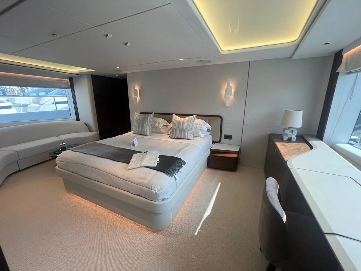 The master stateroom features a luxurious bed, elegant lighting, and ample natural light from large windows. aboard LEILANI Yacht for Sale