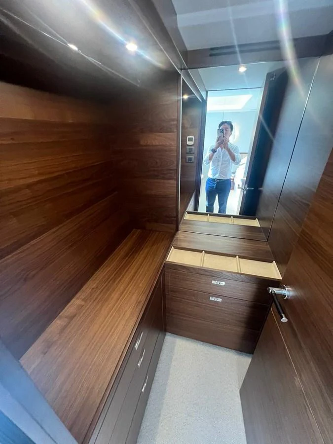 A cozy wooden interior space featuring a mirror and storage compartments. aboard LEILANI Yacht for Sale