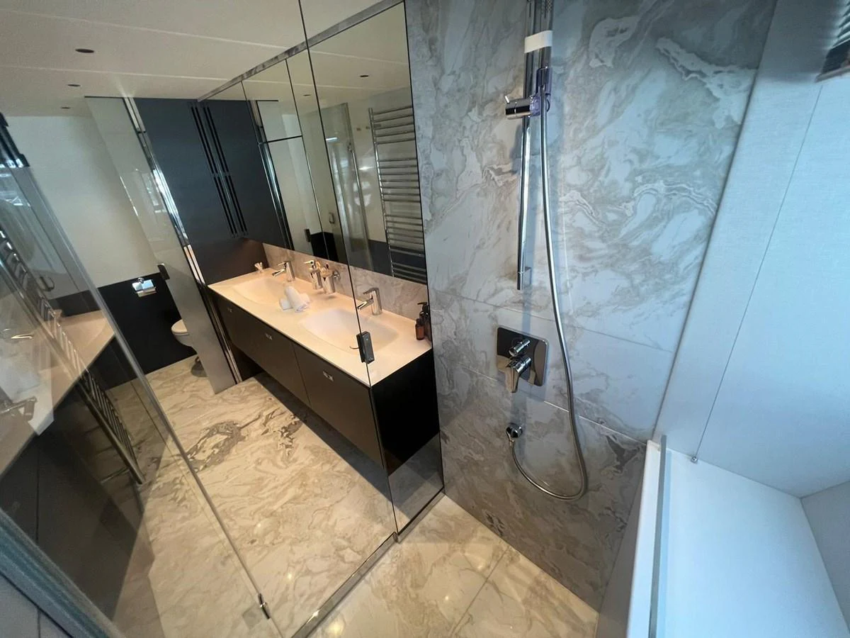 The yacht's bathroom features a luxurious design with marble accents and modern fixtures. aboard LEILANI Yacht for Sale