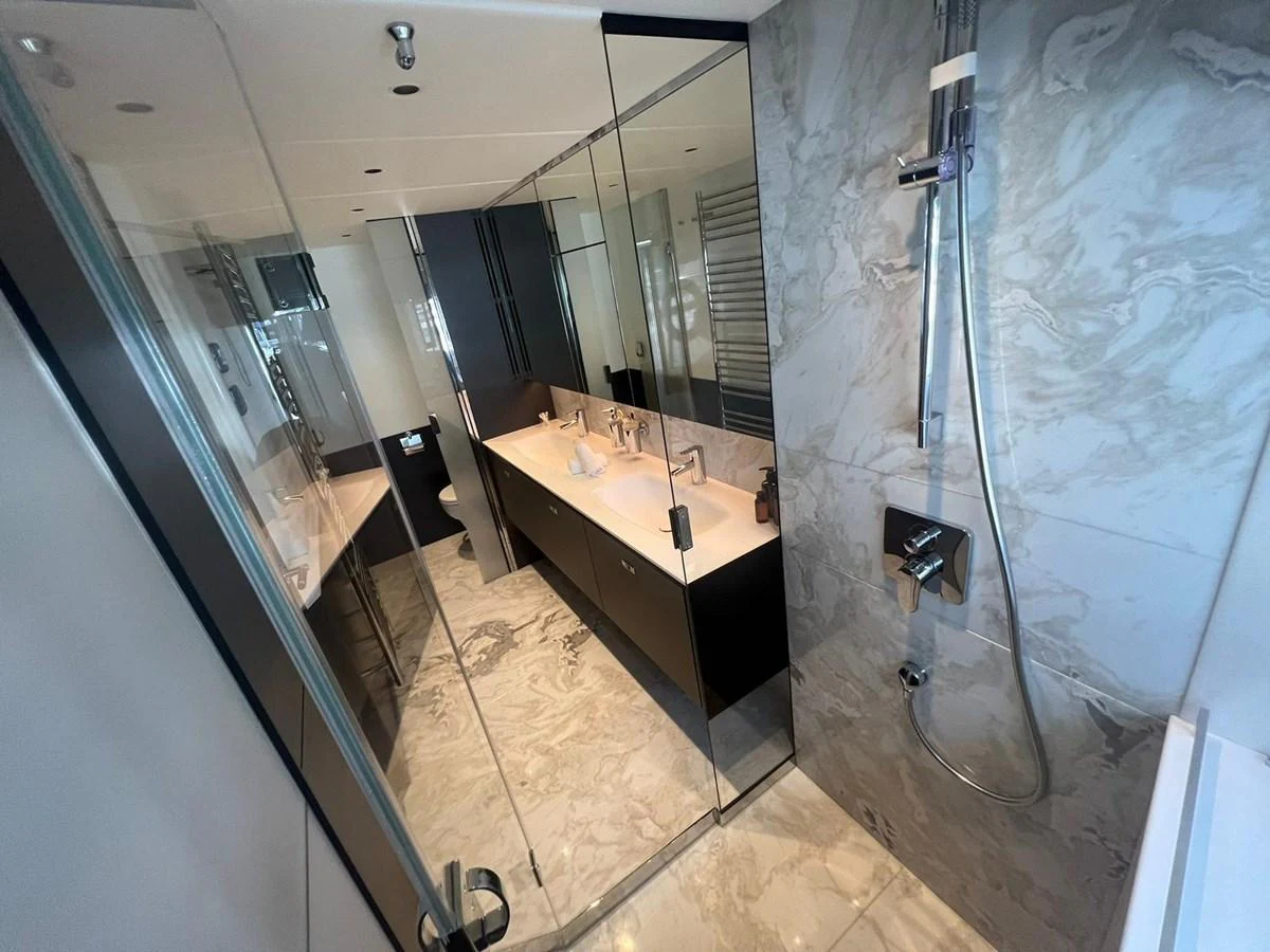 The yacht's bathroom features a sleek design with modern fixtures and a spacious shower area. aboard LEILANI Yacht for Sale