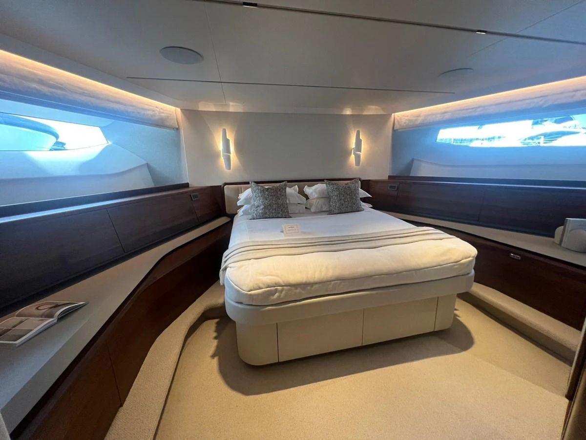The stateroom features a plush bed with elegant lighting and ample natural light from the windows. aboard LEILANI Yacht for Sale