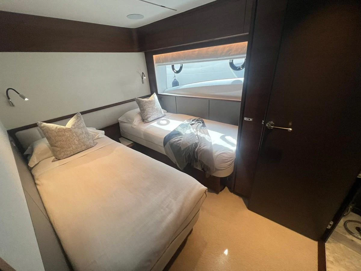 The twin stateroom features two single beds with plush bedding and modern lighting. aboard LEILANI Yacht for Sale