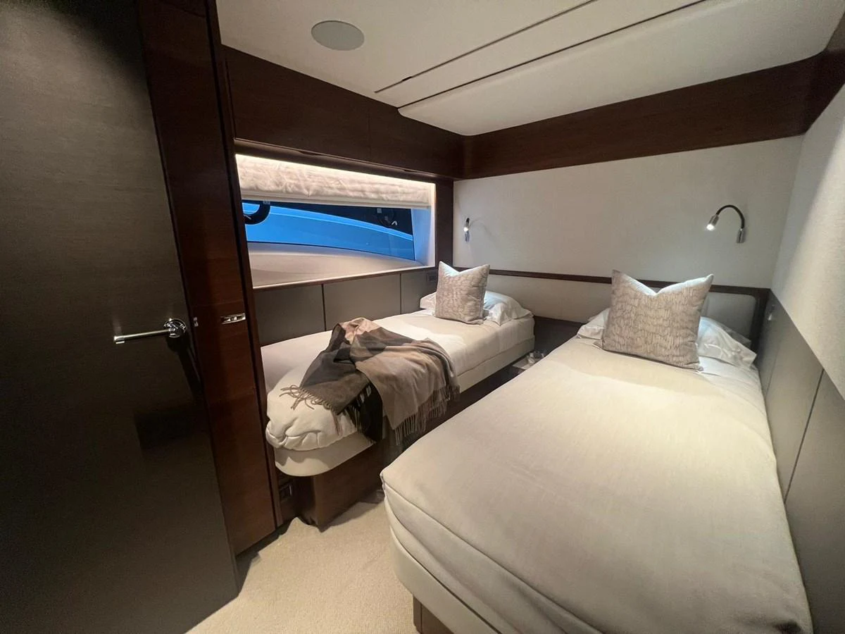 The guest stateroom features twin beds with plush bedding and a cozy ambiance. aboard LEILANI Yacht for Sale