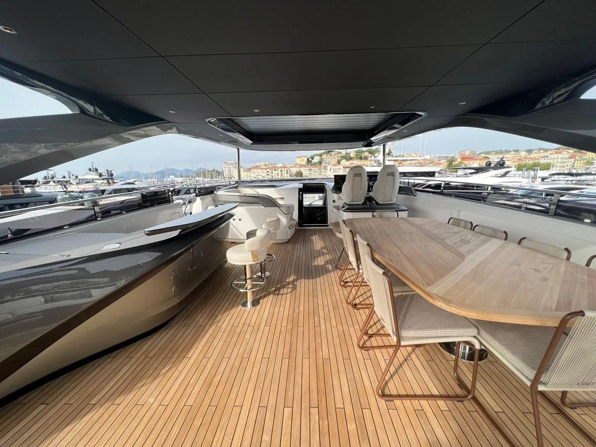 The aft deck features a spacious dining area with a large wooden table and comfortable seating, perfect for alfresco dining. aboard LEILANI Yacht for Sale