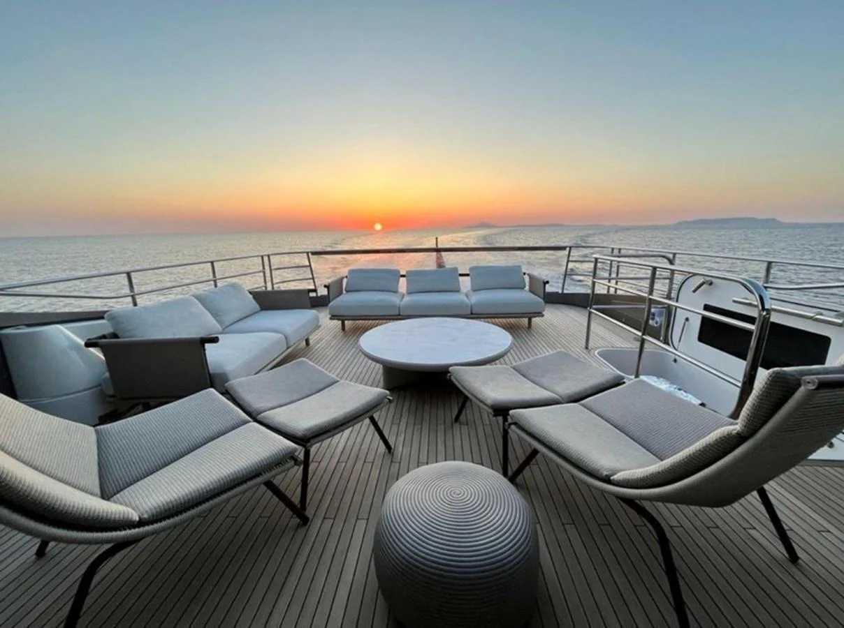 The sundeck offers a serene setting with comfortable lounge chairs and a stunning sunset view over the ocean. aboard LEILANI Yacht for Sale