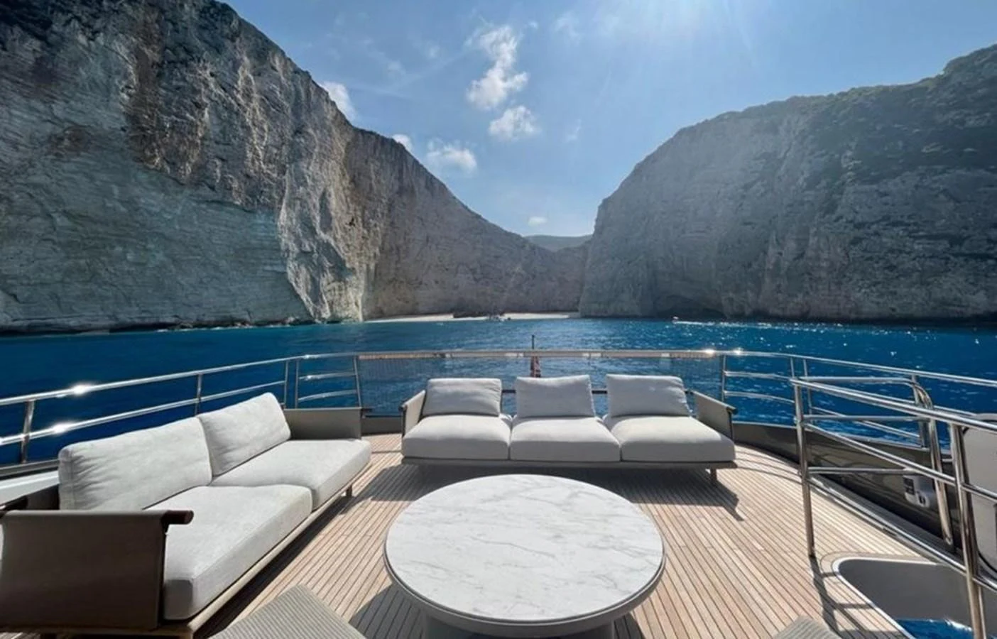 The aft deck offers a luxurious lounging area with stunning views of the surrounding cliffs and clear blue waters. aboard LEILANI Yacht for Sale