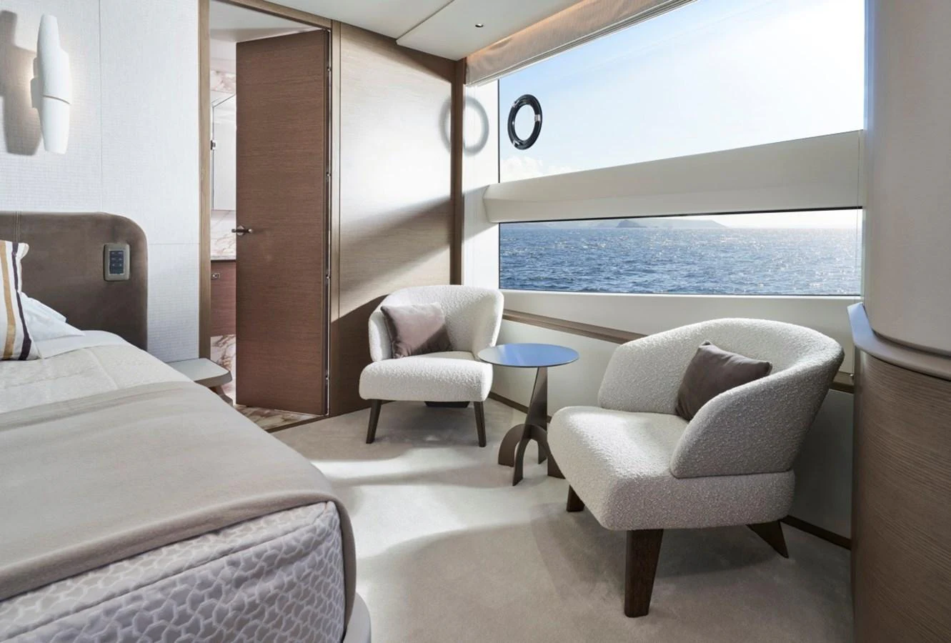 The stateroom features elegant seating with a stunning ocean view through large windows. aboard OCEAN THREE Yacht for Sale