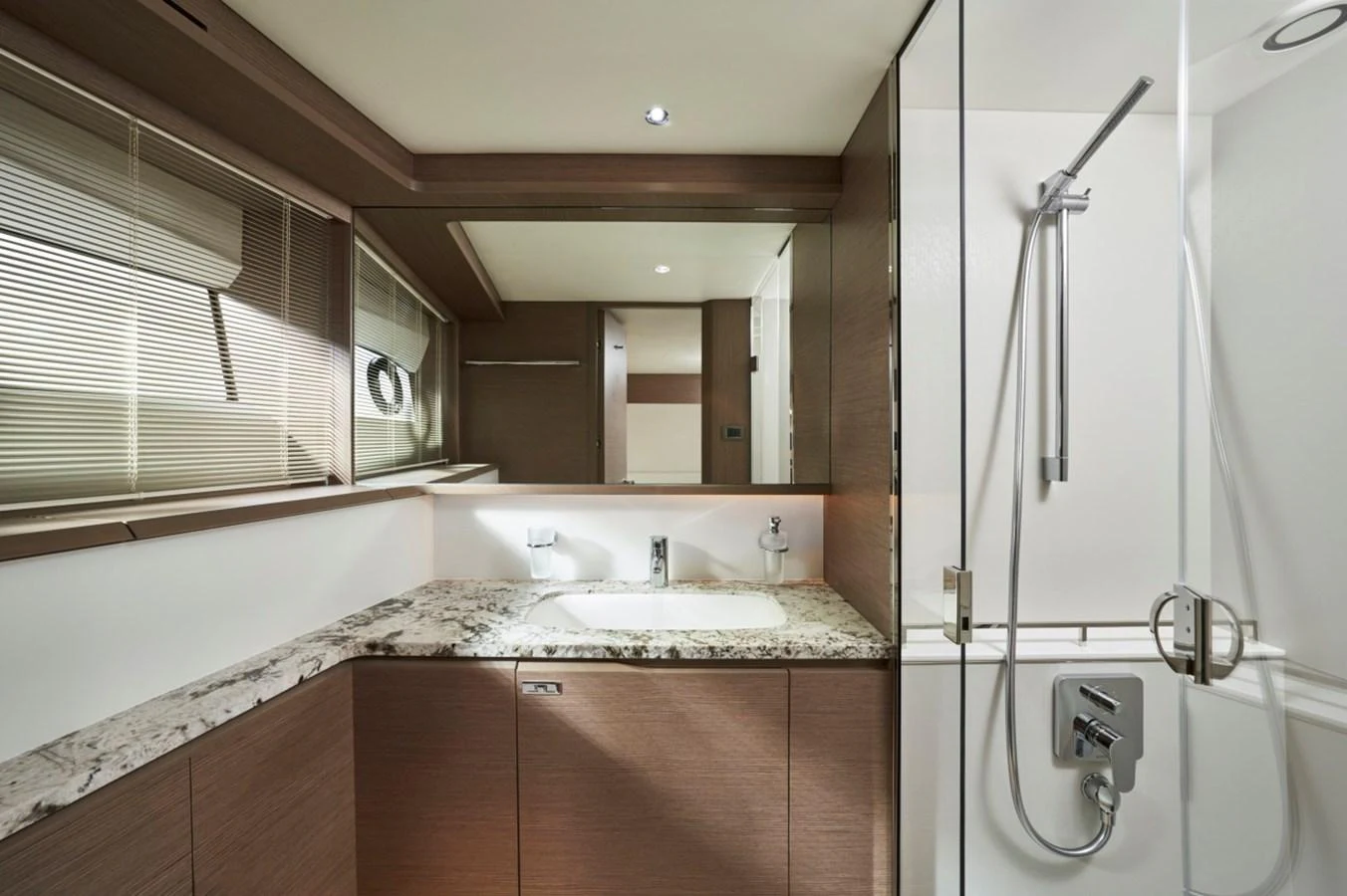 The yacht's bathroom features modern fixtures and a sleek design with ample lighting. aboard OCEAN THREE Yacht for Sale