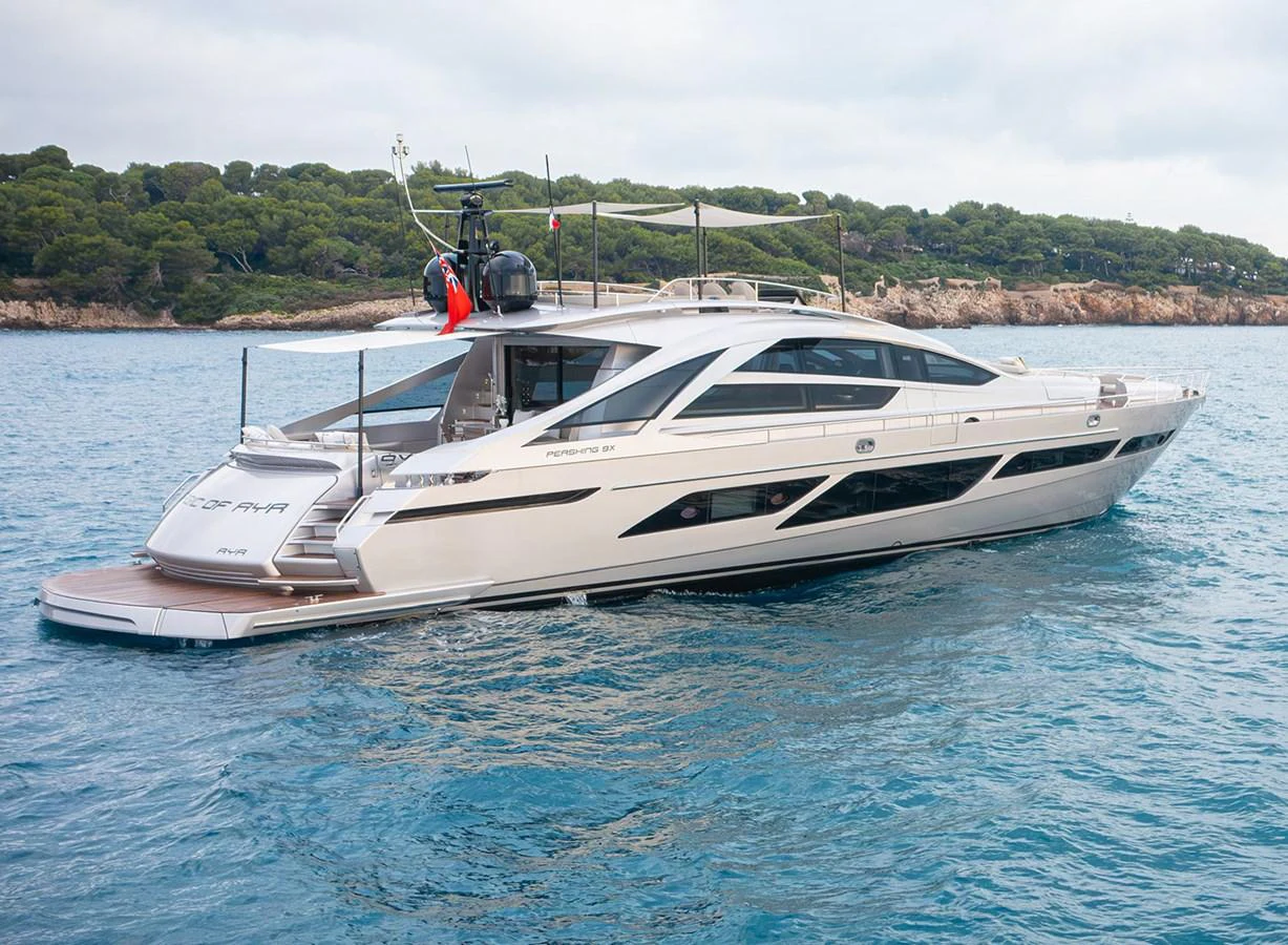 A sleek and modern yacht glides gracefully on calm waters with a scenic coastline in the background. aboard MAGIC OF AYR Yacht for Sale