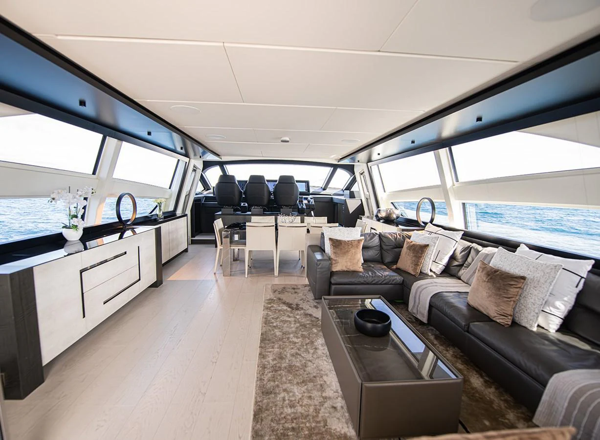 The salon features luxurious seating and modern decor with expansive windows offering stunning ocean views. aboard MAGIC OF AYR Yacht for Sale