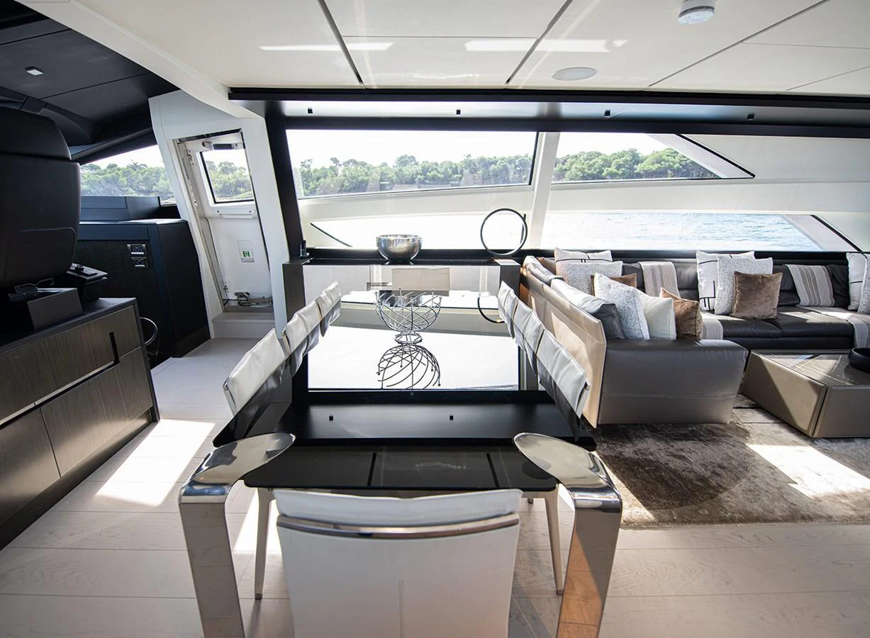 The yacht's salon features a modern dining area and a comfortable seating arrangement with large windows offering scenic views. aboard MAGIC OF AYR Yacht for Sale