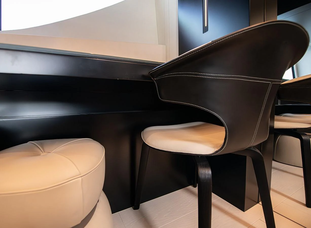A modern and stylish interior seating area with sleek black and white furnishings. aboard MAGIC OF AYR Yacht for Sale