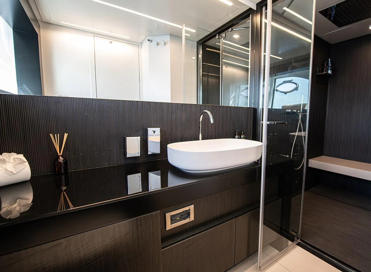 A sleek and modern yacht bathroom with luxurious finishes and ample lighting. aboard MAGIC OF AYR Yacht for Sale
