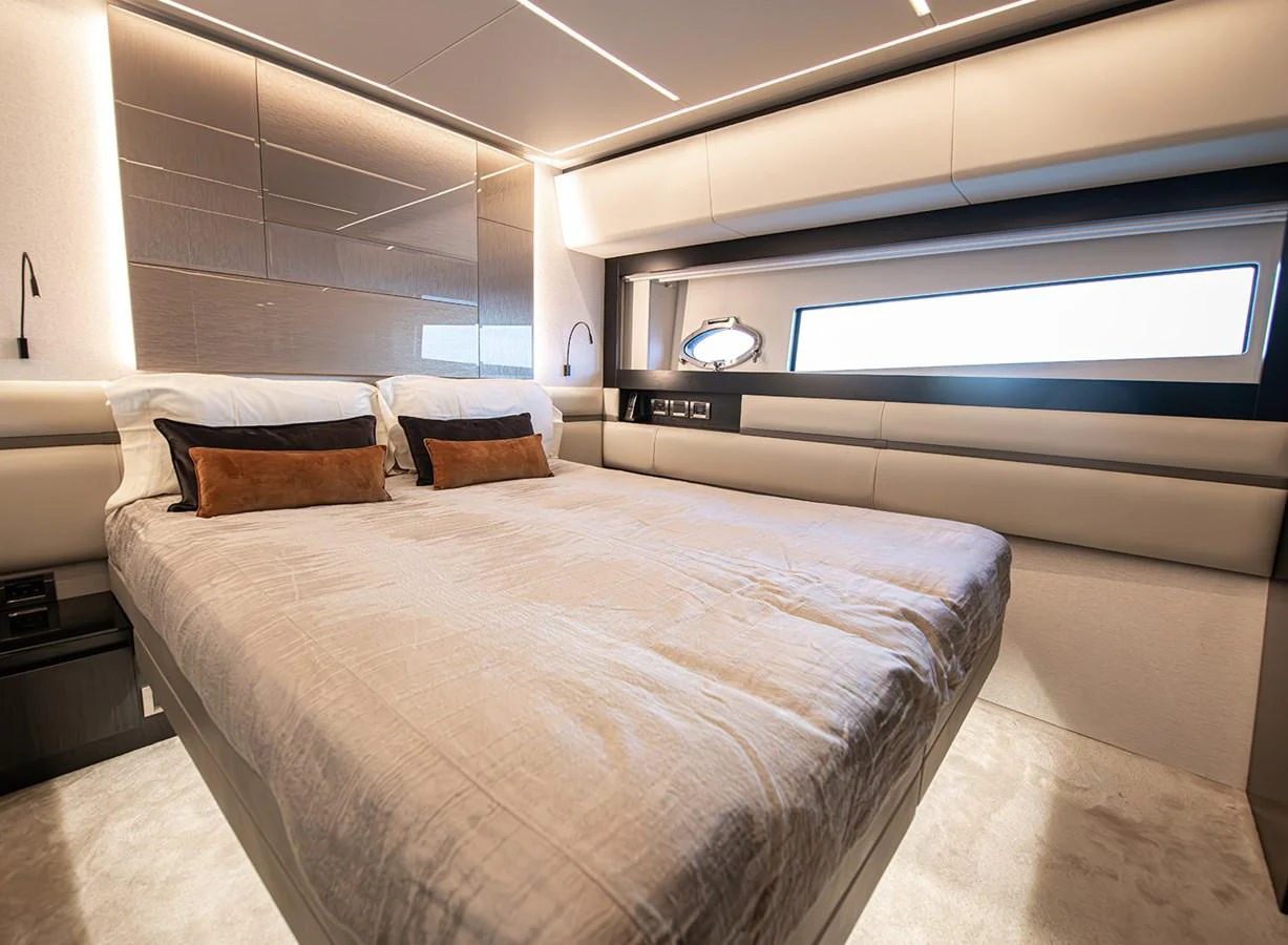 The stateroom features a luxurious bed with modern lighting and a large window for natural light. aboard MAGIC OF AYR Yacht for Sale