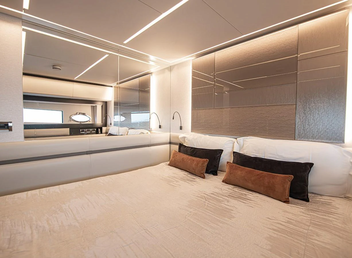 The stateroom features a luxurious bed with plush pillows and modern lighting. aboard MAGIC OF AYR Yacht for Sale