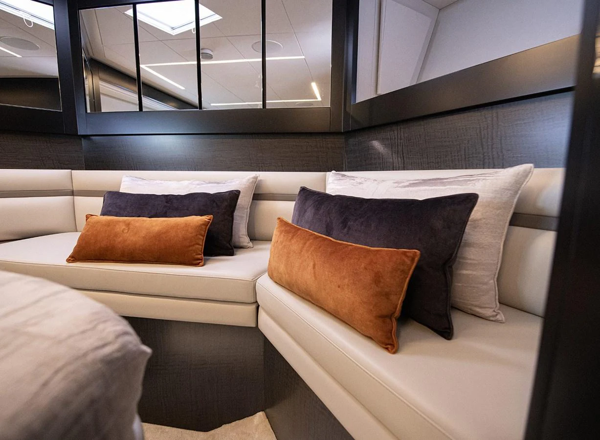 The yacht's interior features a cozy seating area with plush cushions and elegant decor. aboard MAGIC OF AYR Yacht for Sale