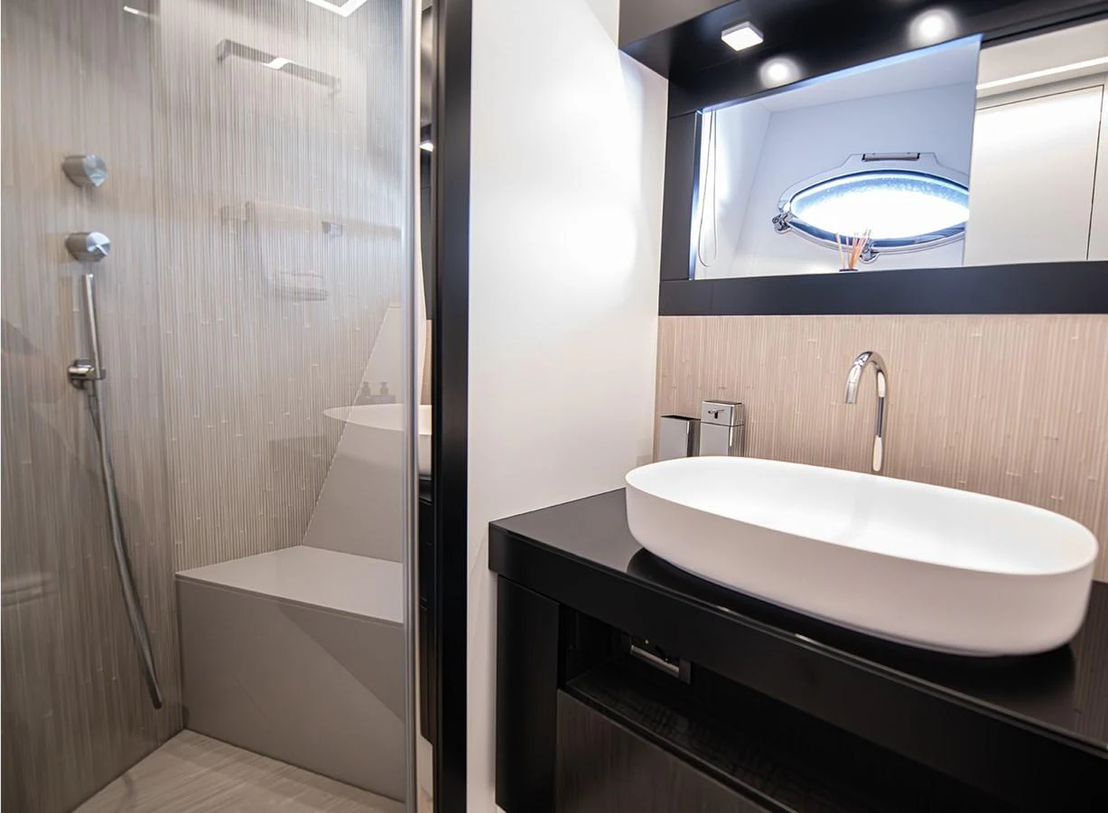 The yacht's bathroom features a modern design with a sleek sink and a spacious shower area. aboard MAGIC OF AYR Yacht for Sale