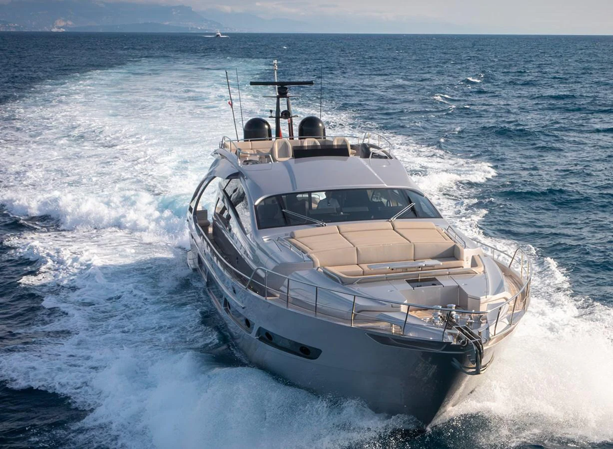 A sleek yacht cruises through the open sea, leaving a trail of white wake behind. aboard MAGIC OF AYR Yacht for Sale