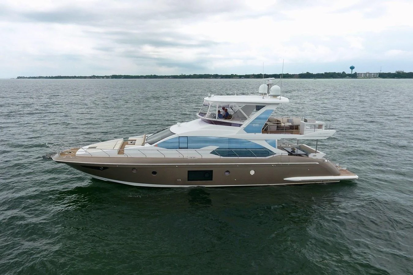A sleek and modern yacht cruising on calm waters with a spacious flybridge and elegant design. aboard KIKI Yacht for Sale