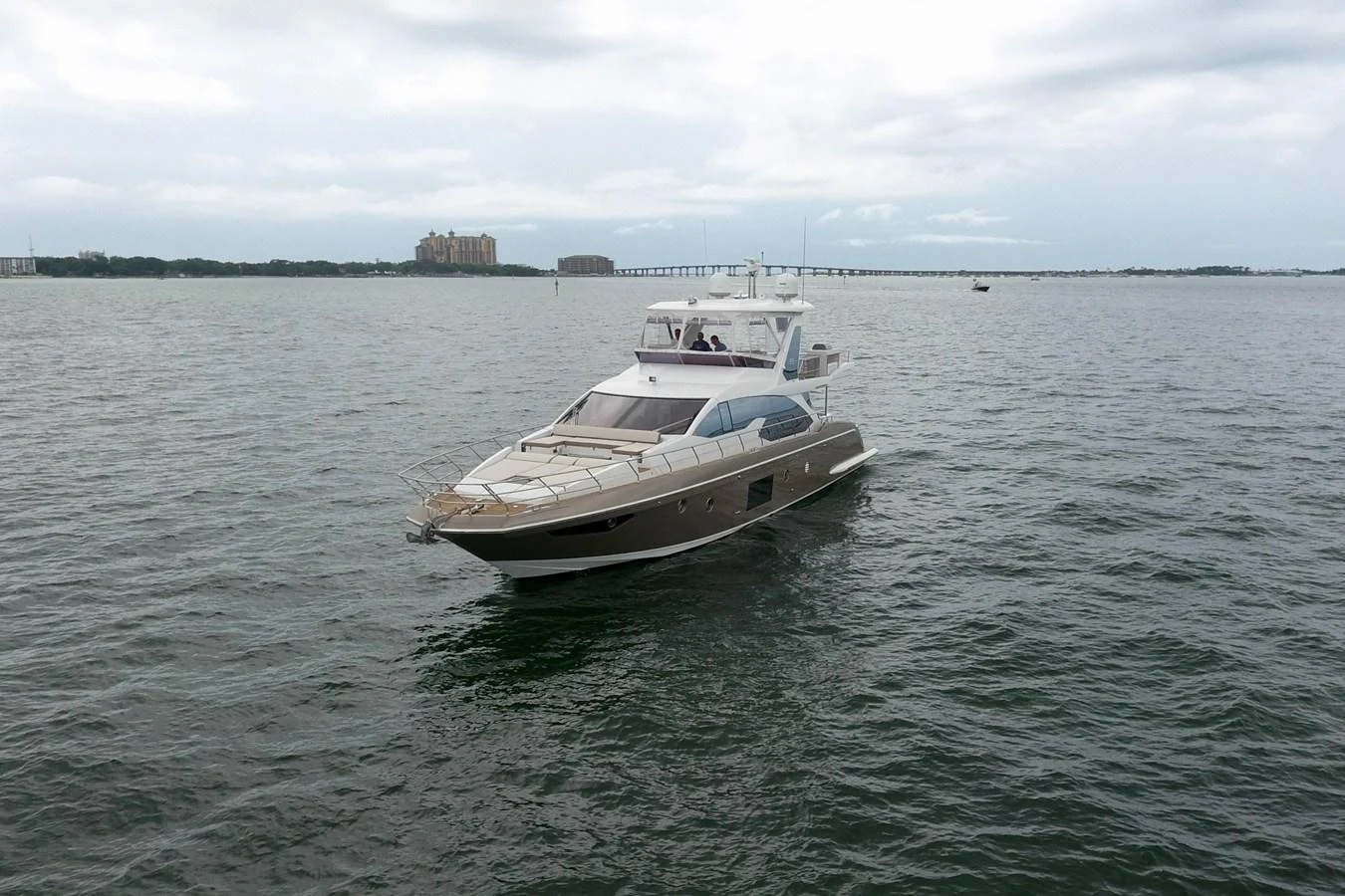 A sleek yacht cruises gracefully on calm waters under a cloudy sky. aboard KIKI Yacht for Sale
