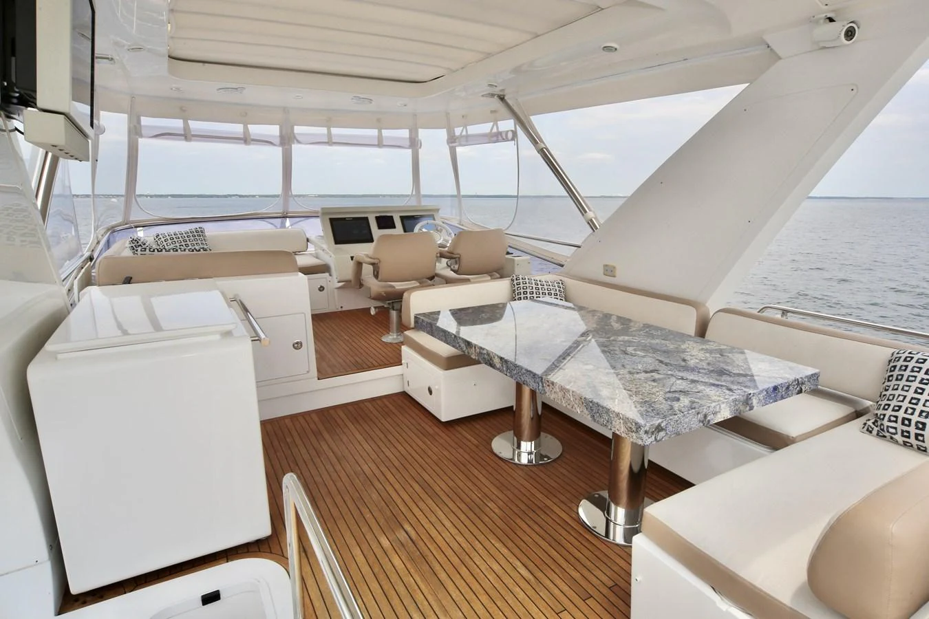 The flybridge offers a spacious and elegant area with a luxurious dining table and comfortable seating, perfect for enjoying the view. aboard KIKI Yacht for Sale