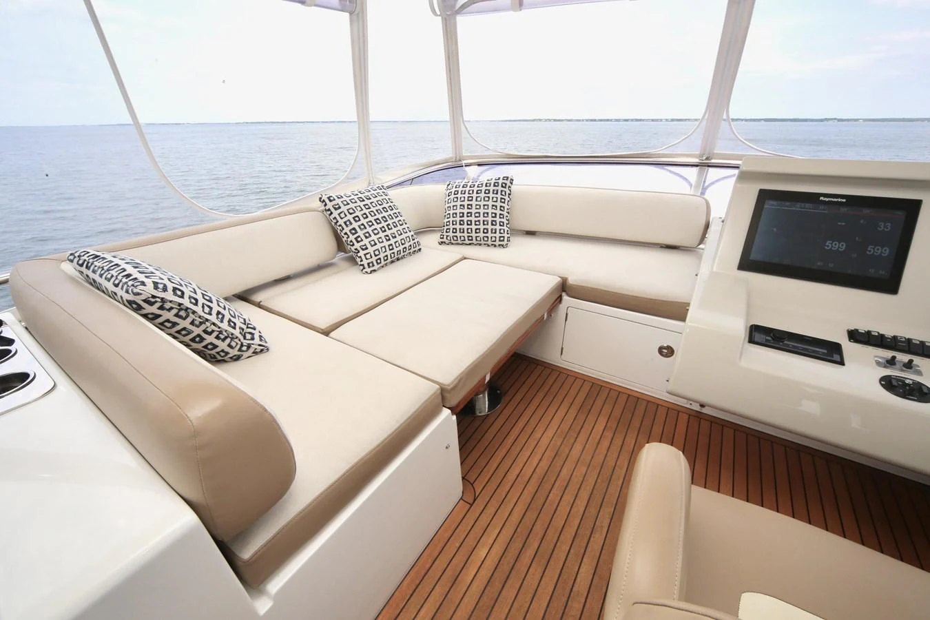 The flybridge features a spacious seating area with plush cushions and a modern control panel, offering a perfect blend of comfort and functionality. aboard KIKI Yacht for Sale