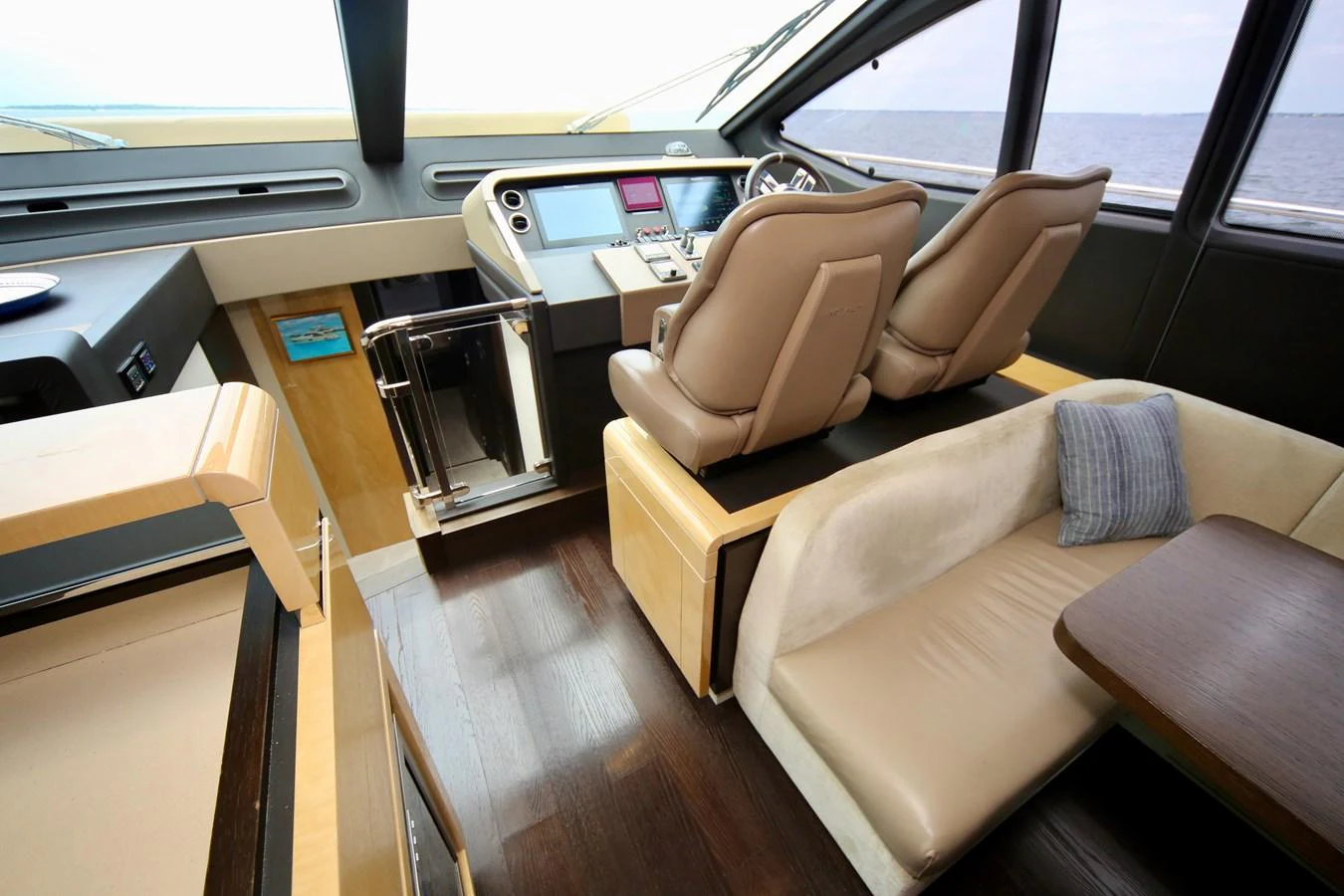 The helm area features plush seating and modern navigation equipment, offering a comfortable and stylish command center. aboard KIKI Yacht for Sale