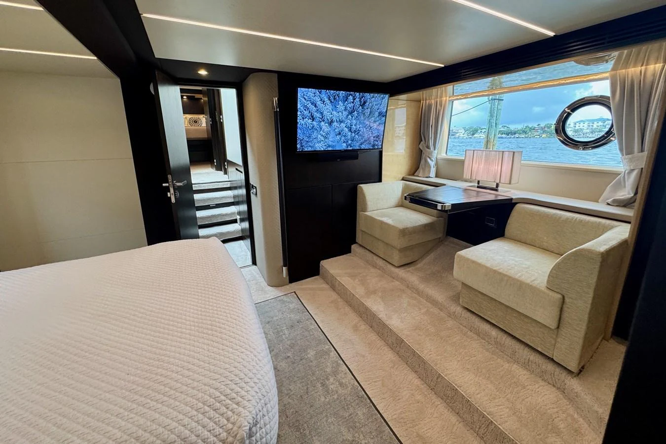 This elegant stateroom features a cozy seating area, a large bed, and a window with a scenic view. aboard KIKI Yacht for Sale