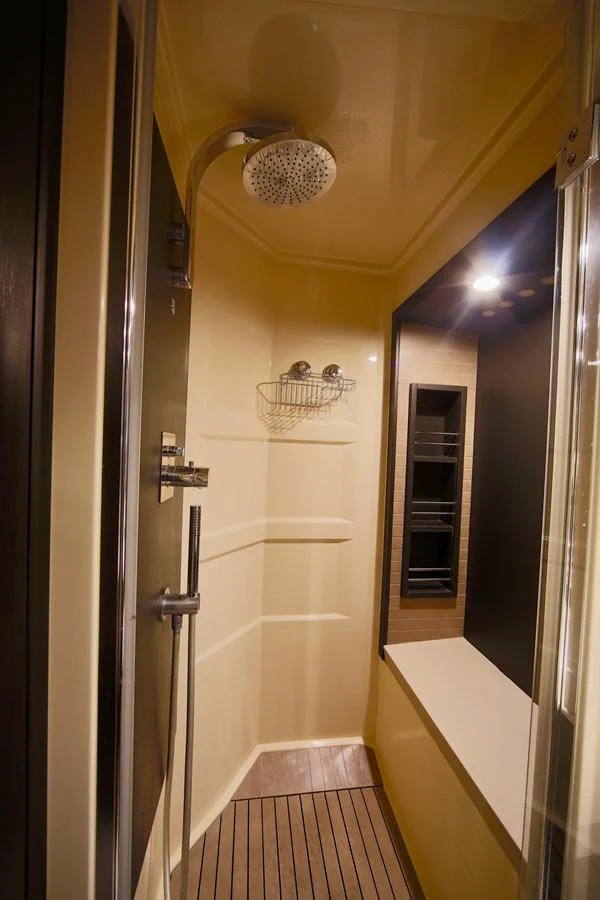 A sleek and modern shower area with a rain showerhead and wooden flooring. aboard KIKI Yacht for Sale
