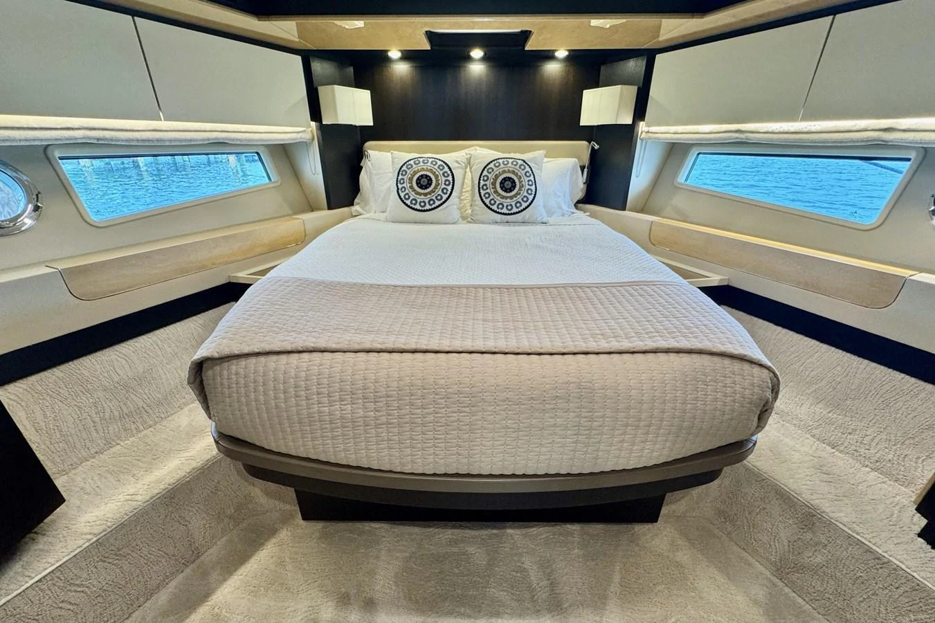 The stateroom features a luxurious bed with elegant bedding and ample natural light from the windows. aboard KIKI Yacht for Sale