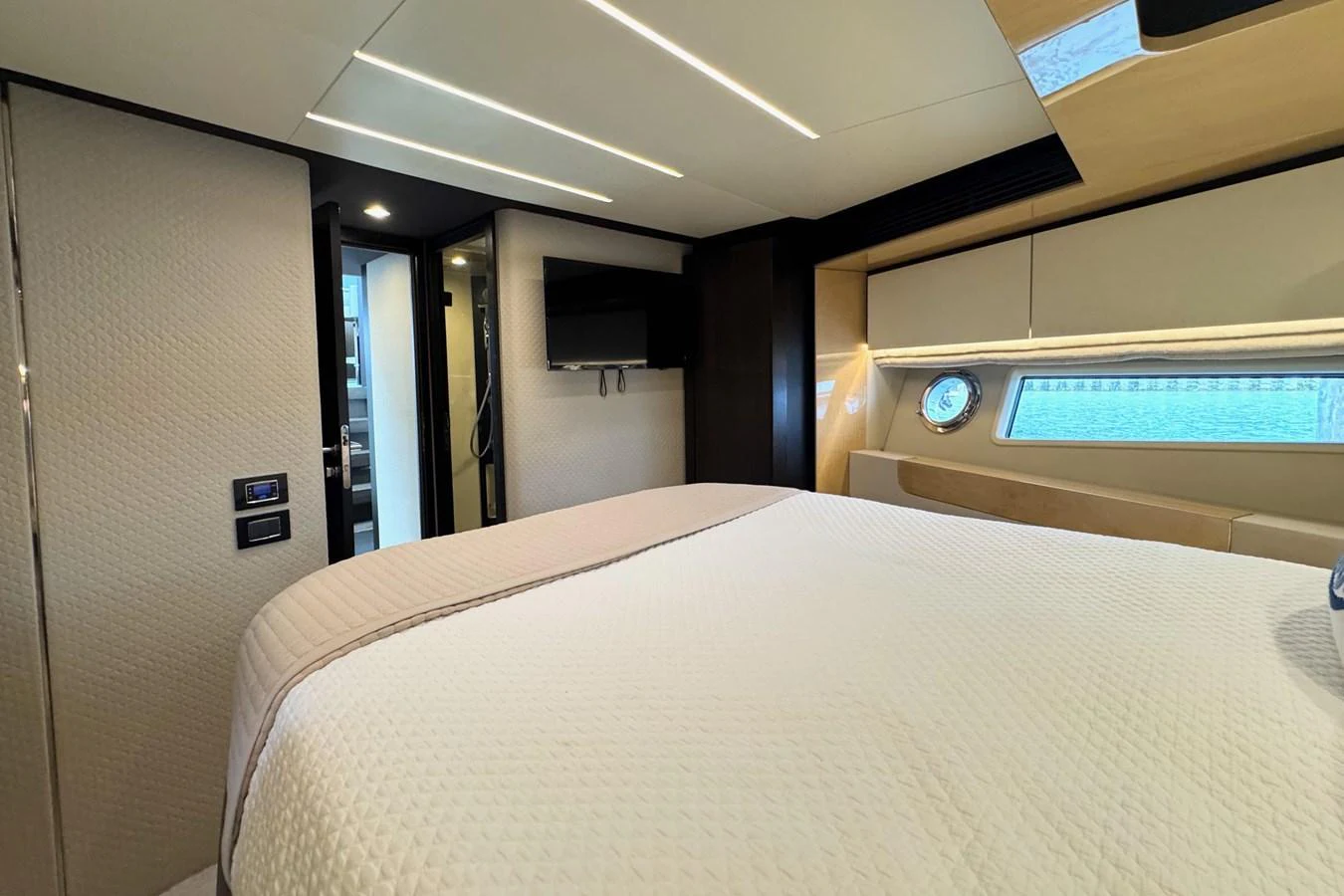 A luxurious stateroom featuring a large bed, modern lighting, and a flat-screen TV. aboard KIKI Yacht for Sale