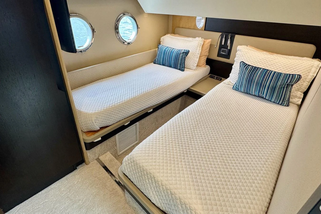 The twin cabin features two single beds with plush bedding and porthole windows for natural light. aboard KIKI Yacht for Sale